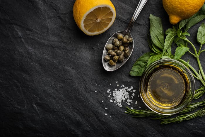Image of capers with olive oil and half of a lemon